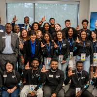 Event attendees all together on stage and giving Anchor Up symbol